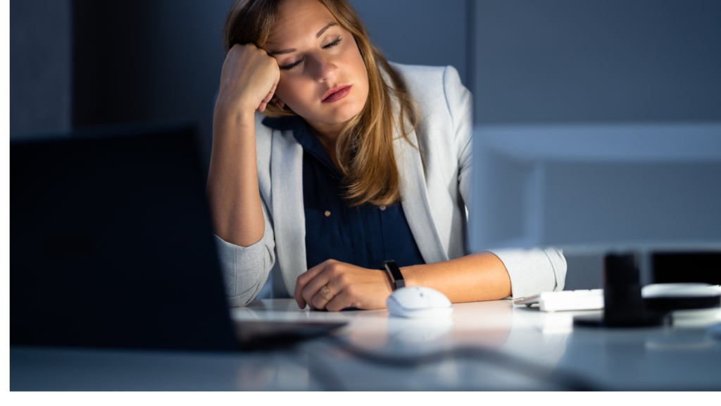 Pavargusi moteris vakare prie kompiuterio